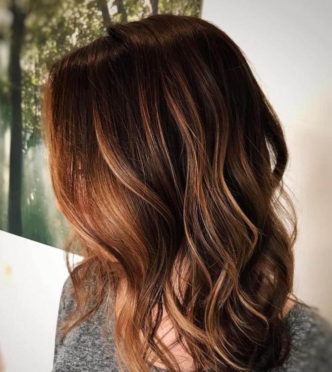 medium-length golden caramel waves on dark chestnut hair look effortlessly chic and very eye-catchy and beautiful