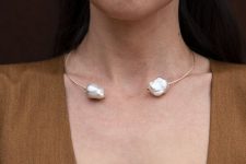 two large white baroque pearls wrapped in gold-filled wire form a choker that wraps around the neck and lays flat at the collar bone