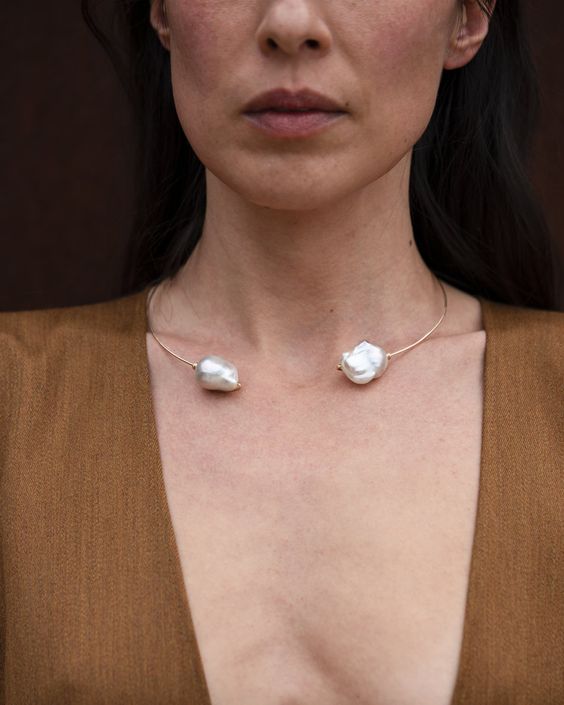 two large white baroque pearls wrapped in gold filled wire form a choker that wraps around the neck and lays flat at the collar bone