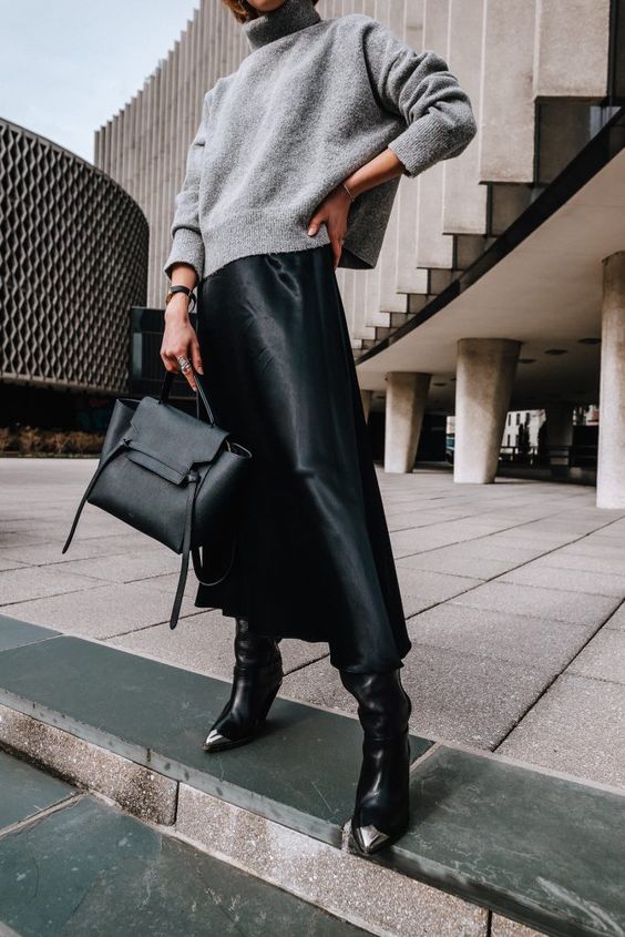a winter work look with a grey oversized sweater, a black satin slip midi, black cowboy boots and a black bag