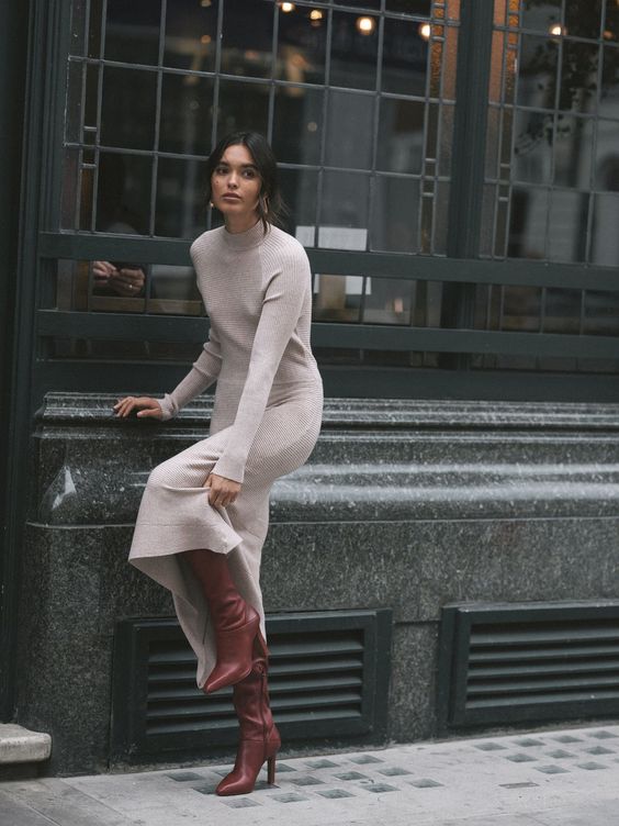 a delicate neutral midi dress with a high neckline and long sleeves, burgundy boots and elegant earrings for a chic look