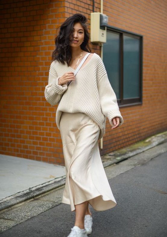 a minimalist monochromatic outfit with a creamy slip midi dress, a ribbed oversized pullover and white sneakers and a bag