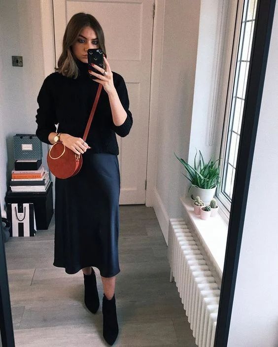 a stylish fall or winter look with a black sweater, a navy slip midi skirt, black boots and a brown bag