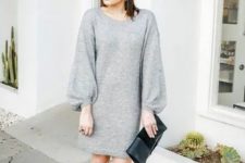 10 an elegant holiday outfit with a grey mini sweater dress, puff sleeves, black sock boots and a black clutch