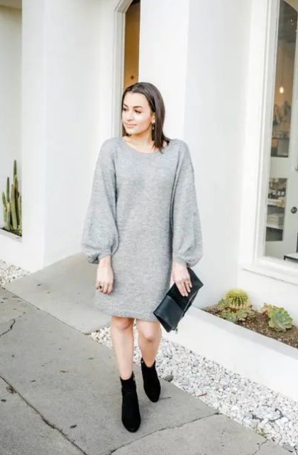 an elegant holiday outfit with a grey mini sweater dress, puff sleeves, black sock boots and a black clutch