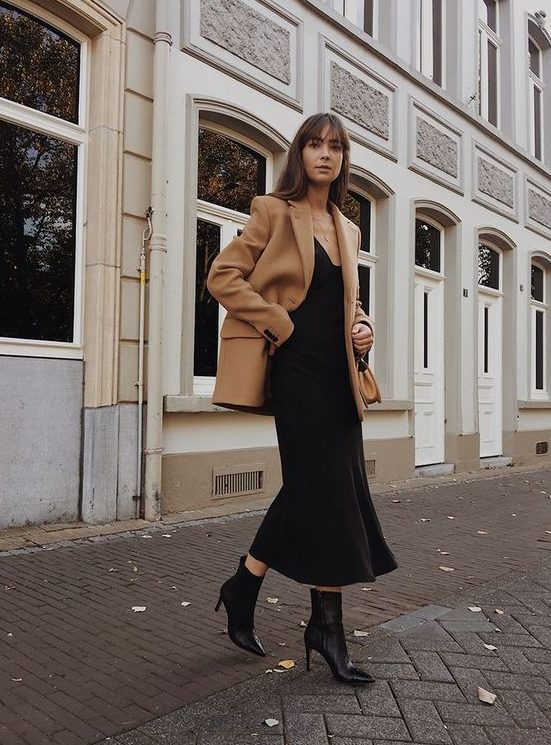 a black slip midi dress, black booties and a camel blazer coat for an ultimately elegant look