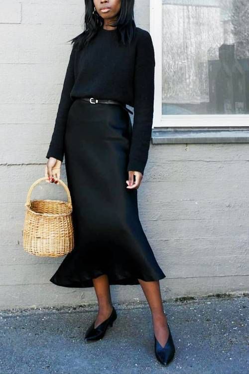a chic fall work look with a black slip midi dress, a black jumper and a belt to highlight the waistline, black shoes and a basket
