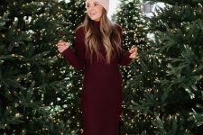 18 a midi burgundy sweater dress wih a turtleneck and long sleeves, white hiking boots and a tan beanie for the holidays