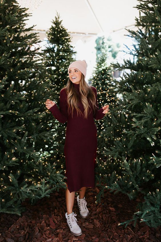 a midi burgundy sweater dress wih a turtleneck and long sleeves, white hiking boots and a tan beanie for the holidays