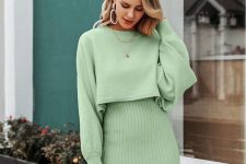 19 a pretty apple green sweater set with a crop sweater with long sleeves and a ribbed high-waisted knee skirt plus layered necklaces