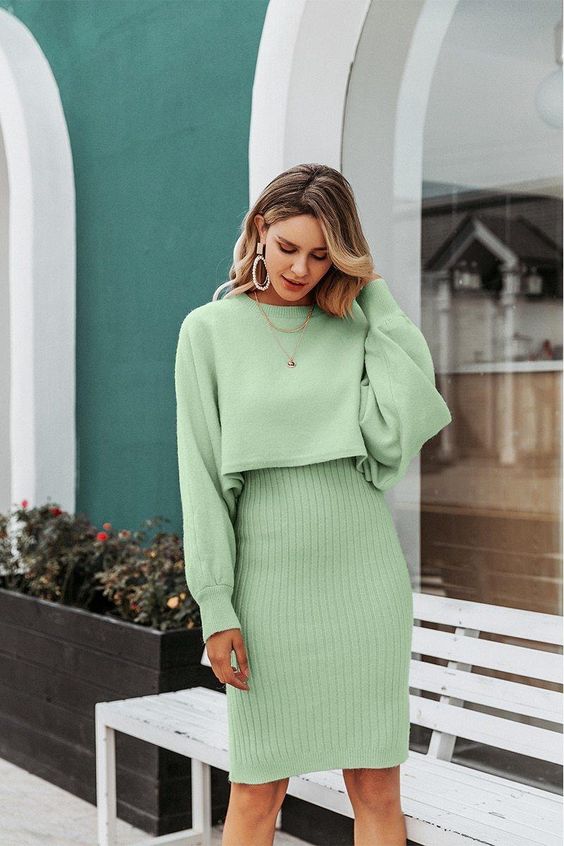a pretty apple green sweater set with a crop sweater with long sleeves and a ribbed high-waisted knee skirt plus layered necklaces