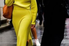 21 an extra bold outfit with a neon yellow turtleneck and an asymmetrical skirt, sheer heels and an amber bag