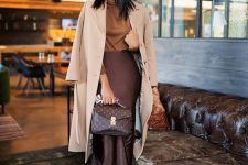 22 a refined work look with a tust-colored turtleneck, a deep purple slip midi skirt, matching shoes, a neutral coat and a brown bag