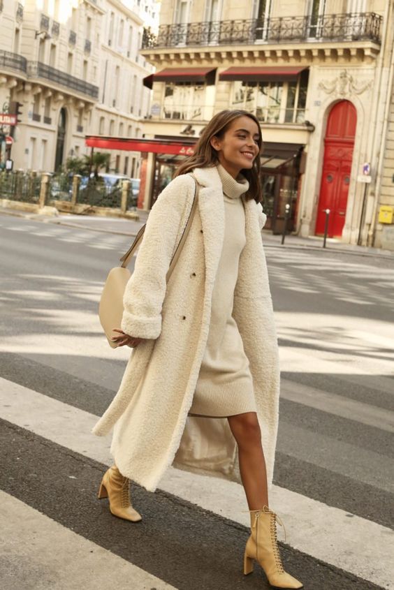 a white knee sweater dress, tan lace up boots, a white faux fur midi coat, a neutral bag for a chic look