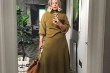 26 a refined look with a knit set with a moss green sweater and a matching A-line midi skirt, an amber bag and purple boots