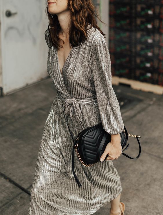 a silver midi dress with a deep V neckline, long sleeves and a sash plus a lovely black bag