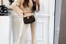 30 a cool neutral knit set with a cropped sweater with bell sleeves and pants, nude boots and a brown printed bag