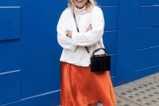31 a simple fall work look with an oversized white sweater, an orange slip midi, black boots, a black bag