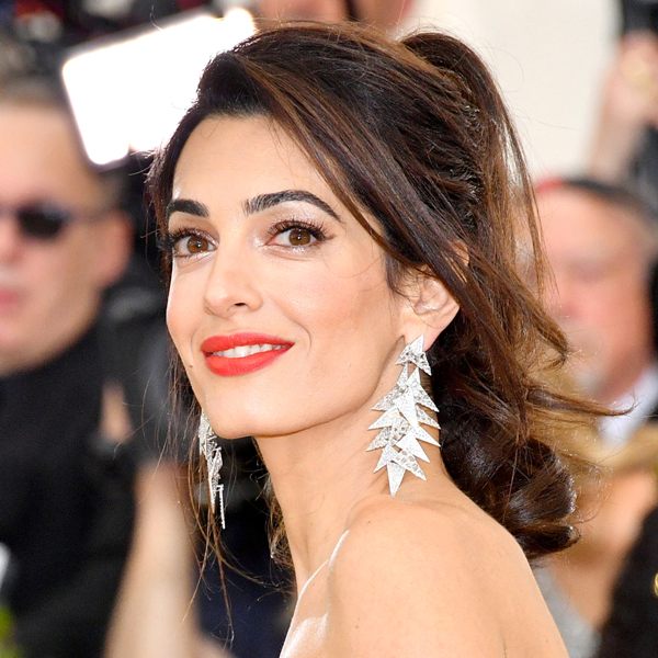 Amal Clooney rocking a tousled ponytail with curls and locks down and with slightly teased roots