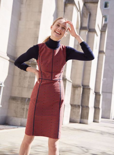 An outfit with a navy blue turtleneck and a printed sleeveless knee-length dress
