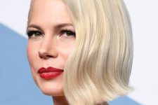 Michelle Williams wearing creamy blonde hair, a short bob with hair mostly on one side and a slight wave for more elegance