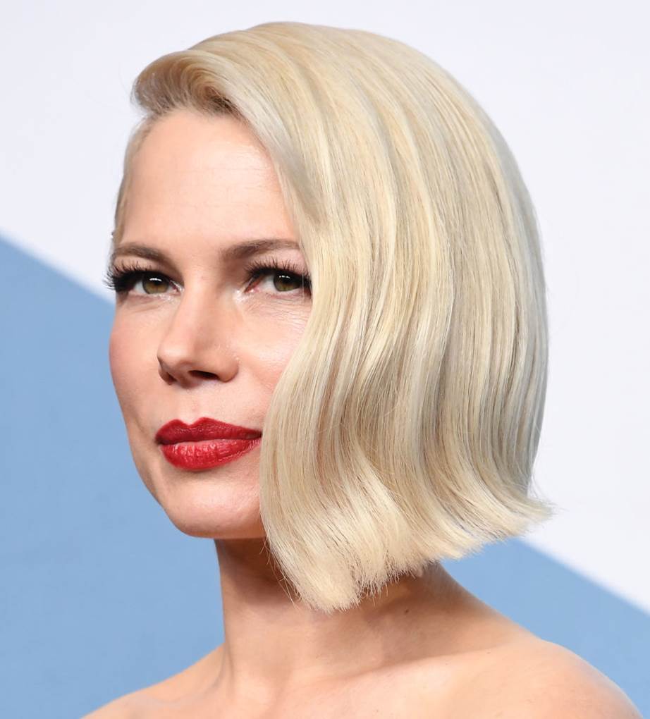 Michelle Williams wearing creamy blonde hair, a short bob with hair mostly on one side and a slight wave for more elegance