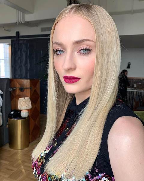 Sophie Turner wearing creamy blonde long hair for a soft and chic look, a perfect warm tone of blonde