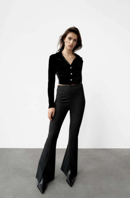 With black high-waisted flare trousers and black leather boots