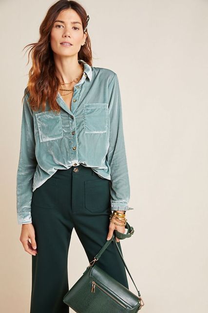 With emerald green high-waisted flare pants and green leather bag