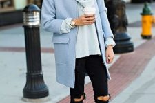 With light blue loose sweater, light blue coat, sunglasses, black distressed skinny pants and black suede heeled boots
