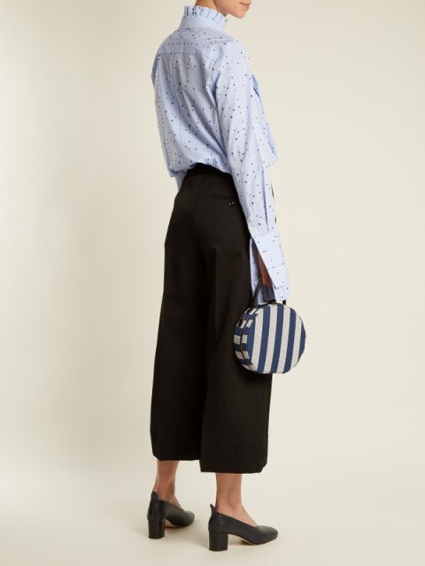 With light blue printed ruffled long sleeved shirt, black high waisted culottes and black heeled shoes