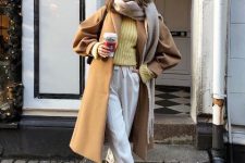 With light yellow sweater, gray fringe scarf, sunglasses, white cuffed culottes, black bag and beige suede mid calf boots