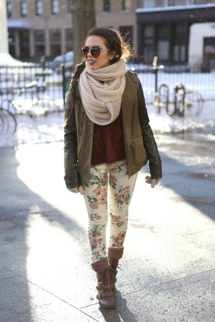 With marsala sweater, floral printed skinny pants, olive green jacket, rounded sunglasses and lace up mid calf boots