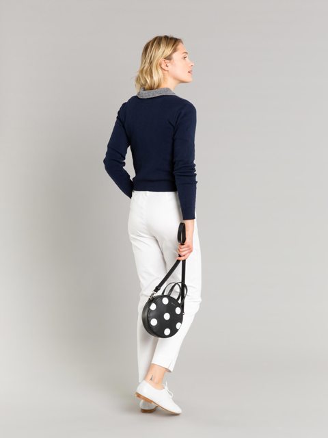 With navy blue and gray sweater, white cropped pants and white lace up flat shoes