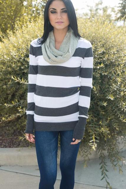 With white and gray striped long sleeved shirt and jeans