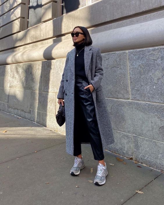 a black turtleneck, black leather trousers, a grey midi coat, grey trainers and a black bag for fall or winter