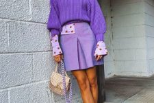 a bright outfit with a purple chunky knit sweater, a lilac and red polka dot shirt, a periwinkle mini skirt, lilac shoes and a neutral bag