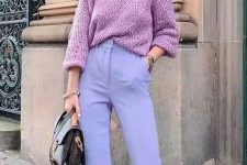 a pastel outfit with a pink patterned sweater, periwinkle flare trousers, a black bag and statement earrings