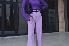 a purple turtleneck sweater, periwinkle palazzo pants, a black belt and a black woven bag