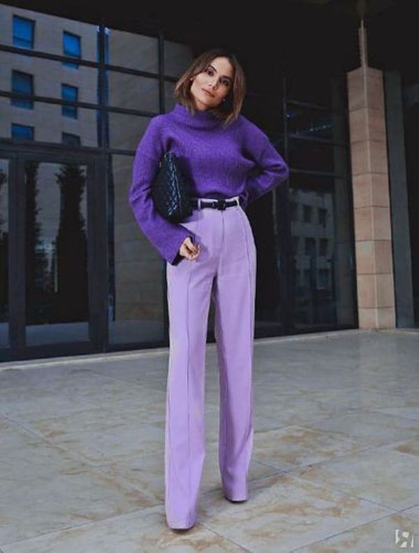 a purple turtleneck sweater, periwinkle palazzo pants, a black belt and a black woven bag