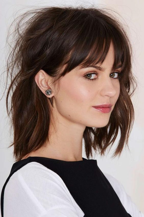 a textural and messy long bob with bangs and done in cold brew tones is a very chic and very French-like hairstyle