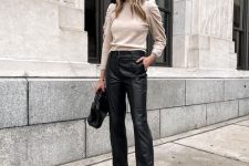 an elegant look with a neutral jumper with puff sleeves, black leather trousers, black shoes and a bag will be nice for work