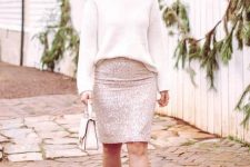 an oversized creamy turtleneck sweater, a silver sequin knee skirt, nude shoes and a small white bag for a party