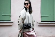 an oversized white turtleneck sweater, a pink sequin midi skirt, white sneakers and a grey trench plus a black bag