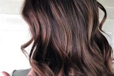 fantastic long and wavy cold brew hair with burgundy and caramel balayage is amazing and super lovely