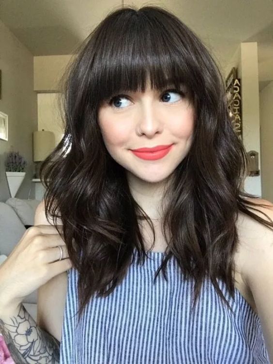 medium length cold brew hair with bangs and with much texture looks nonchalant and very chic