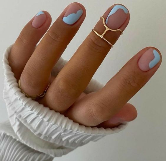 a matte nude and pastel blue manicure with abstract patterns is a cool solution to try