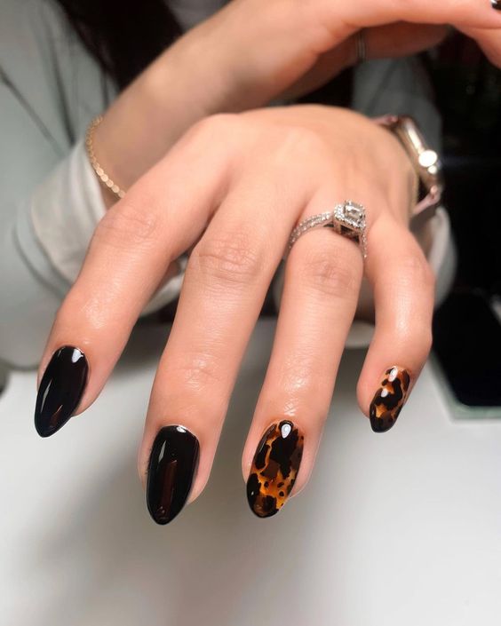 a gorgeous deep burgundy manicure with bold orange and black printed accents are a dramatic and bold idea