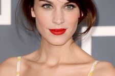 Alexa Chung rocking a messy auburn updo with locks down and some side bangs looks amazing