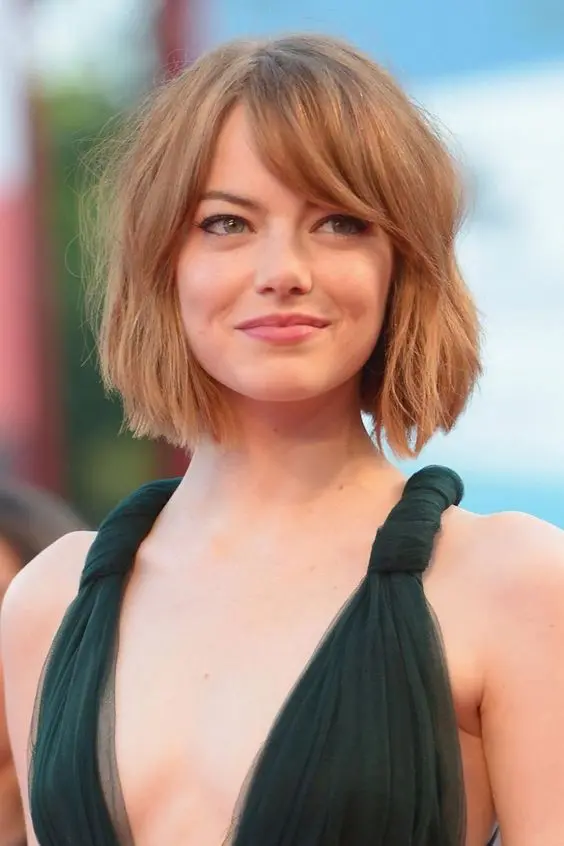 Emma Stone with a short textural bob and bottleneck bangs for a catchier and bolder look